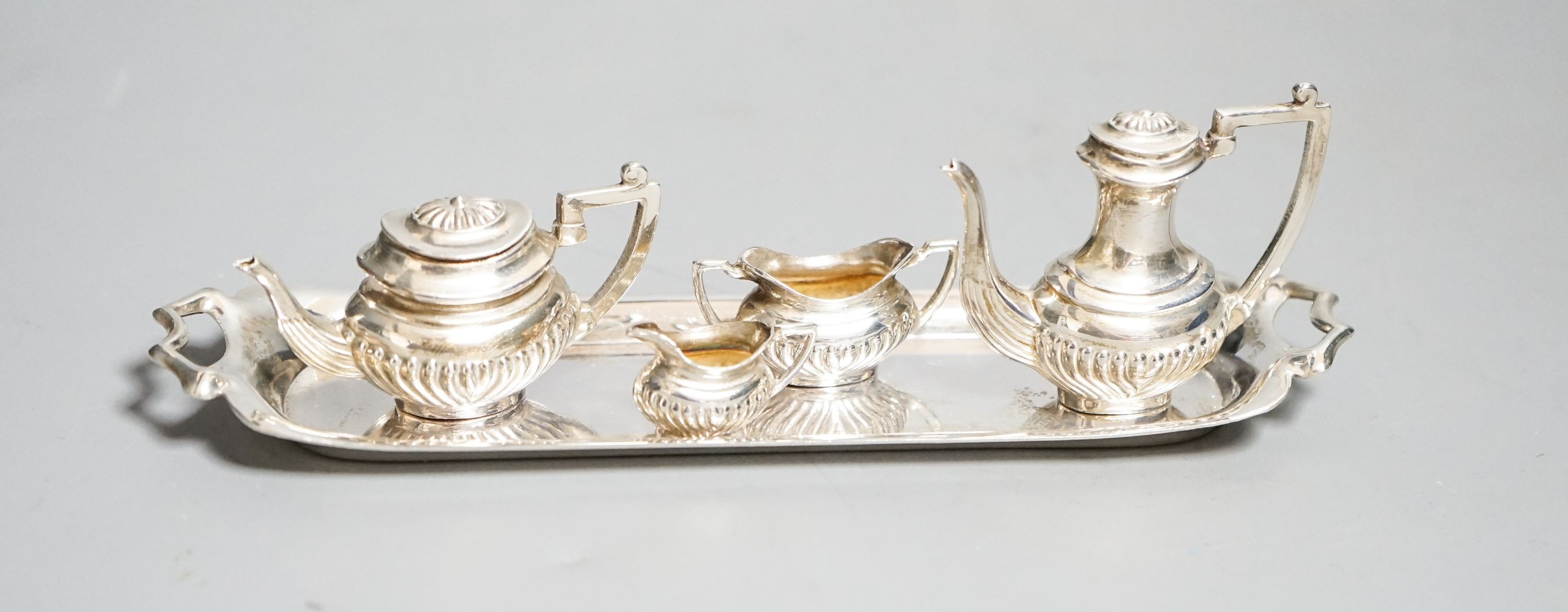 A modern silver miniature four piece tea set and two handle tea tray, London, 1979, tray 14.8cm.